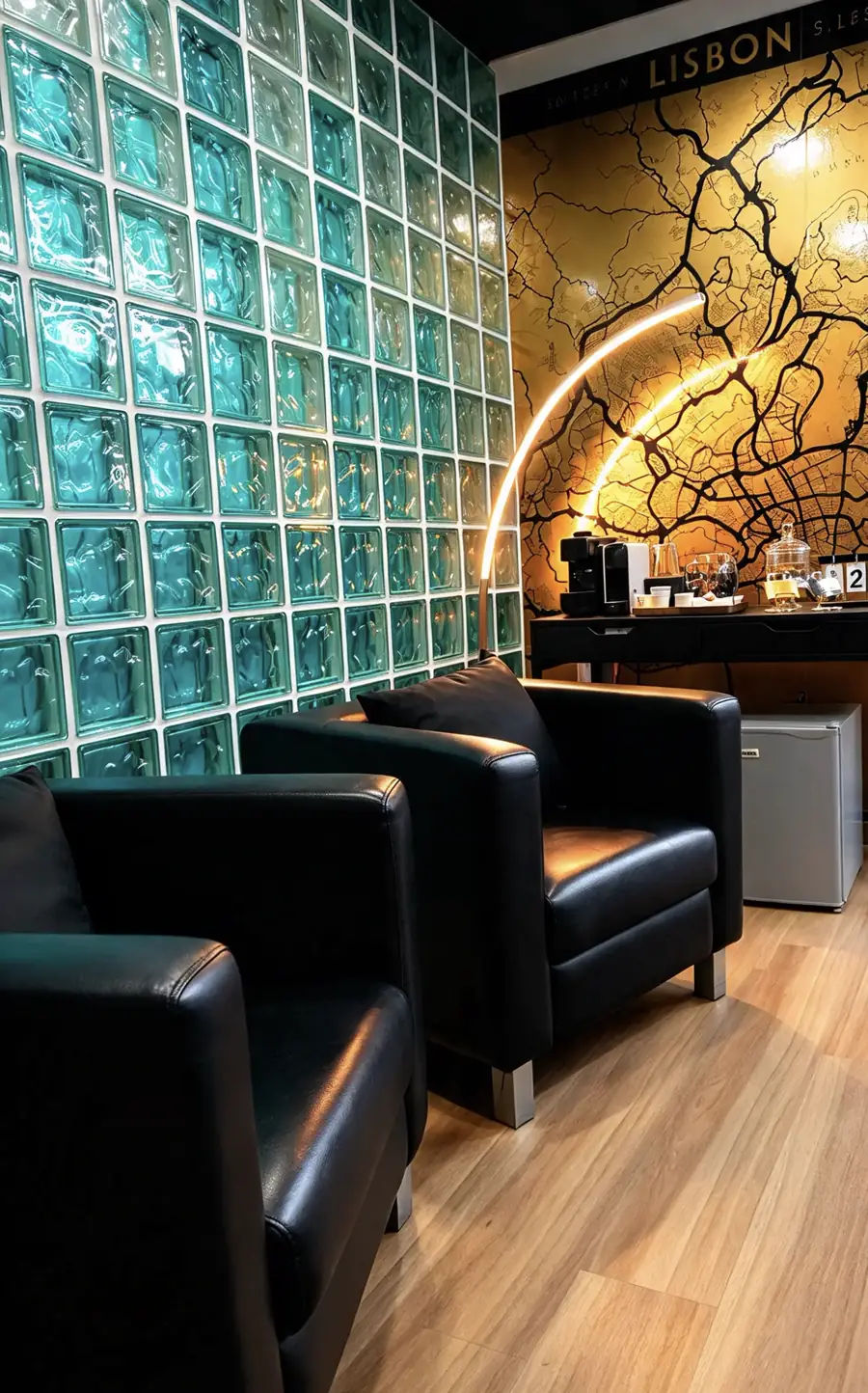 Sala de espera com poltronas de pele e parede de tijolo de vidro