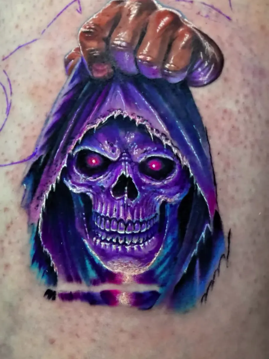 Tatuagem a cores de caveira encapuzada em roxo