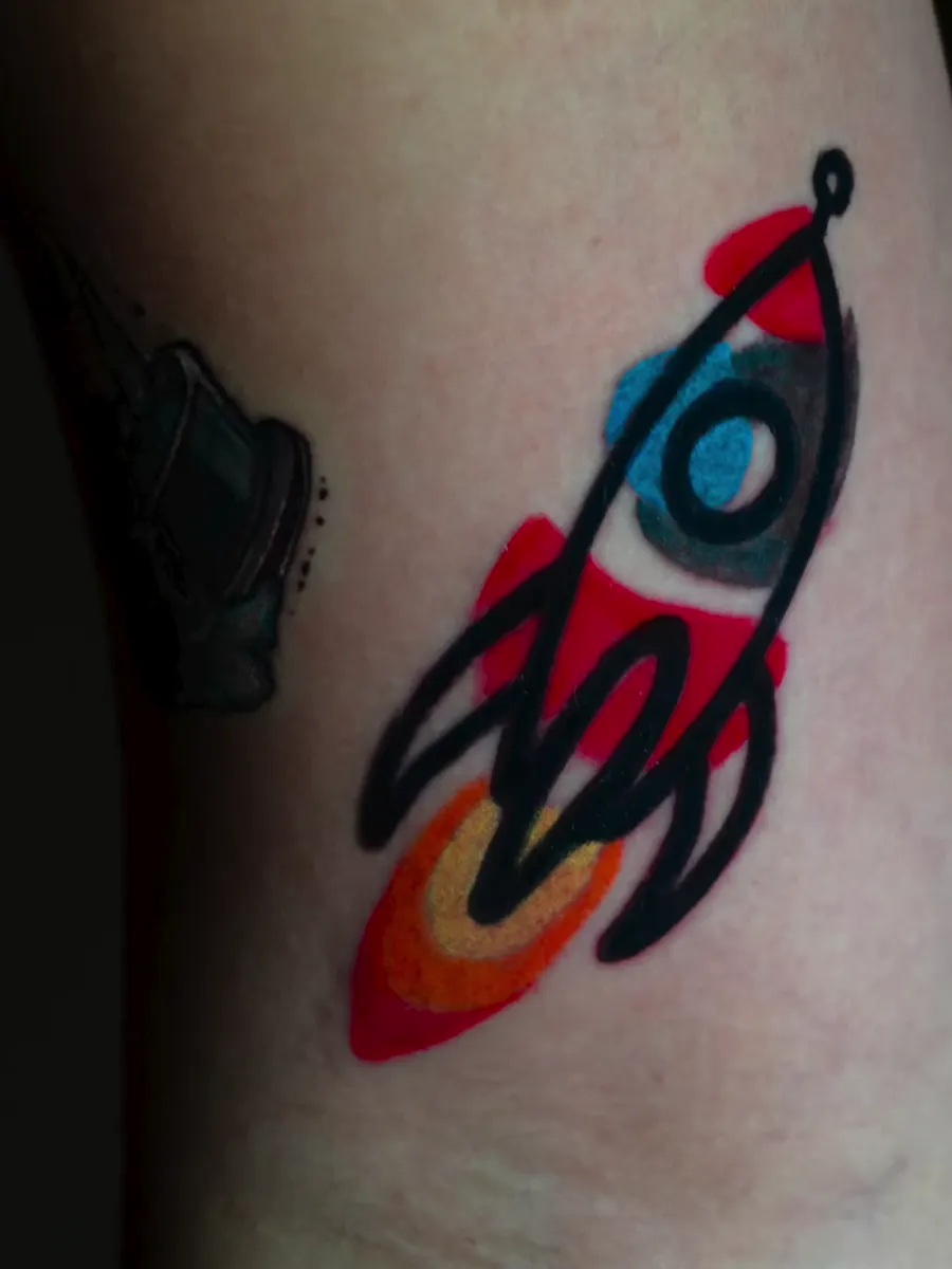 Tatuagem pequena a cores de um foguetão